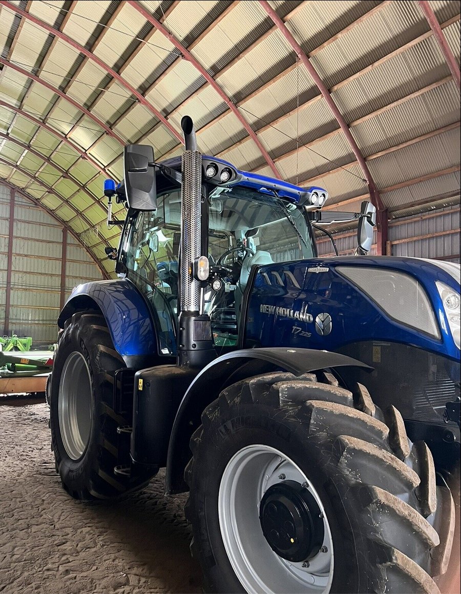 Polished stainless steel exhaust guard installed on a tractor