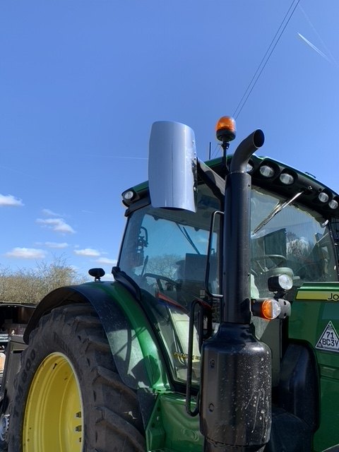 Stainless steel mirror guard fitted to a tractor